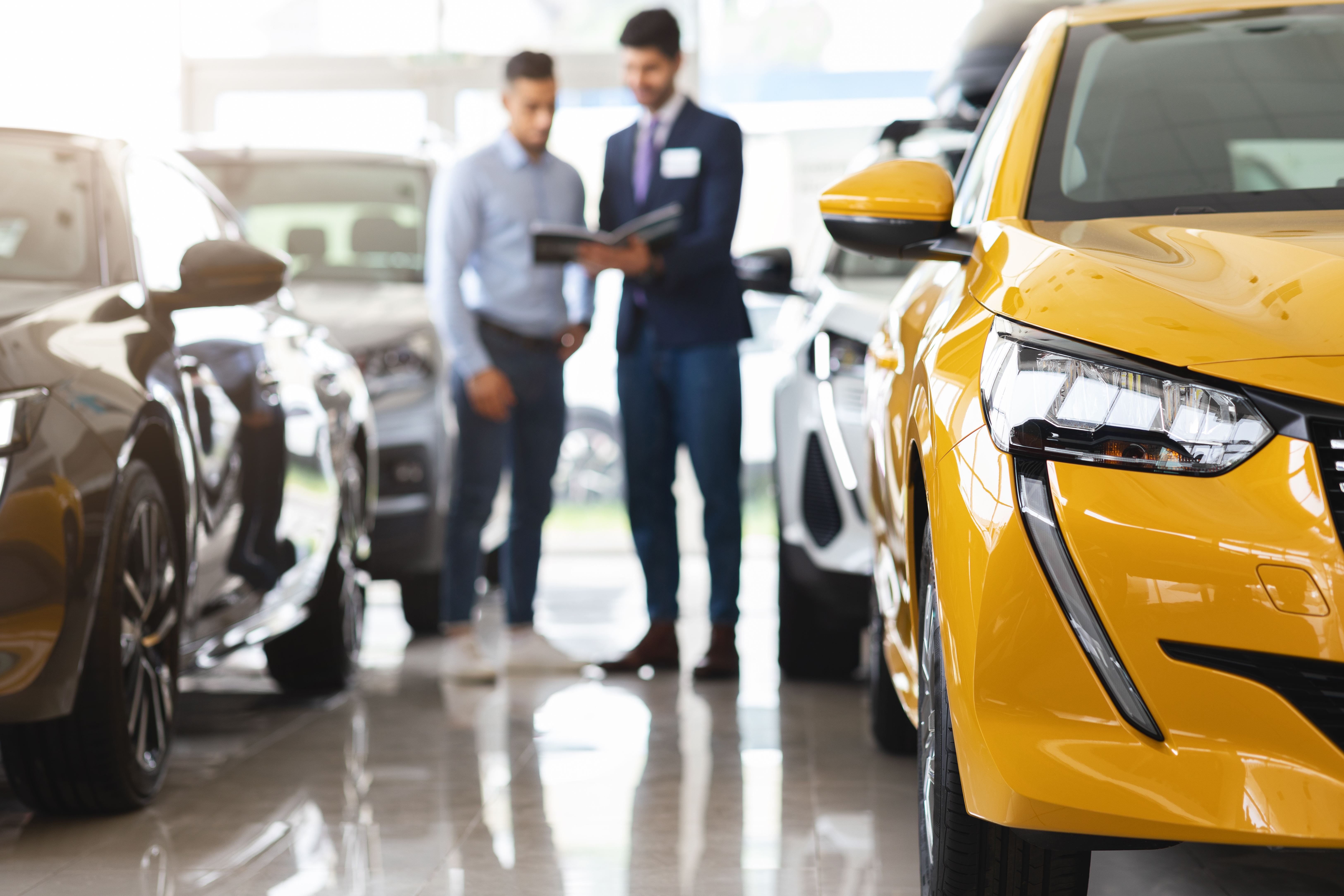 This image represents a customer having discussion with the sales agent in a car showroom.